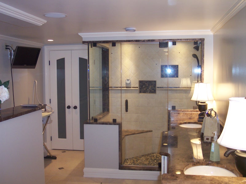Master bathroom with glass walk-in shower, double vanity, and marble accents