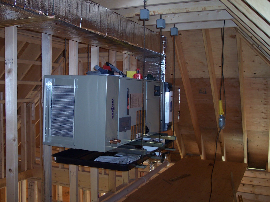 Trane AquaCoil air handler suspended from attic rafters with insulated ductwork