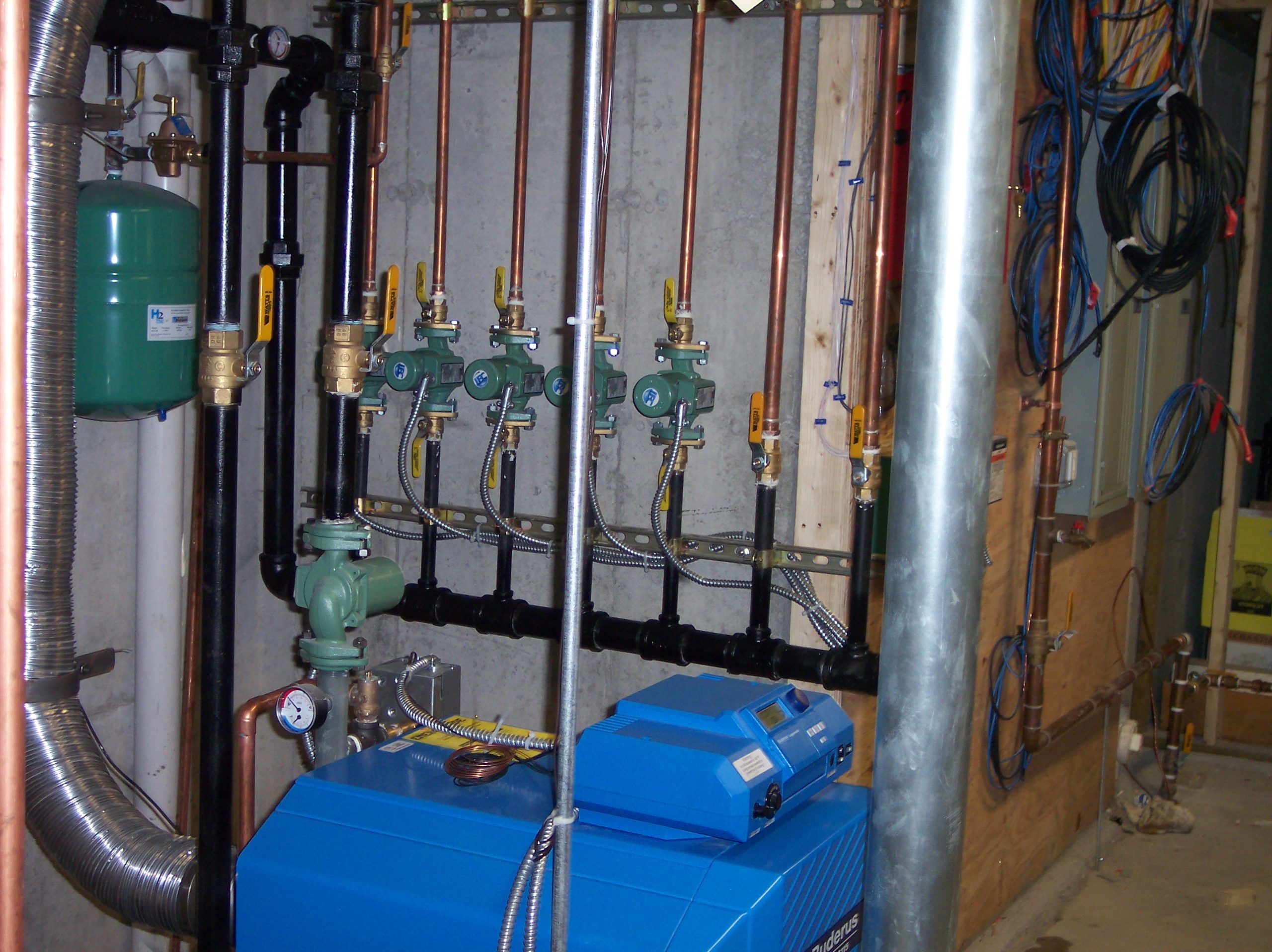 Buderus boiler with circulator pumps and copper piping in a basement mechanical room